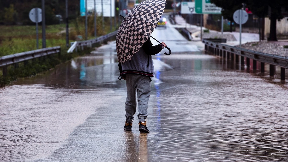 Un hombre se resguarda de la lluvia con un paraguas