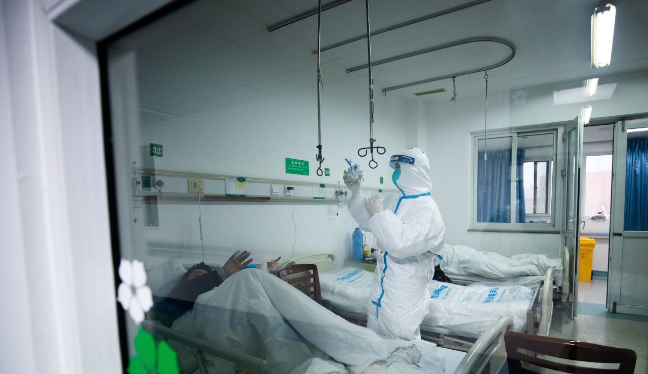 Un sanitario atendiendo a un paciente en un hospital de Wuhan, China