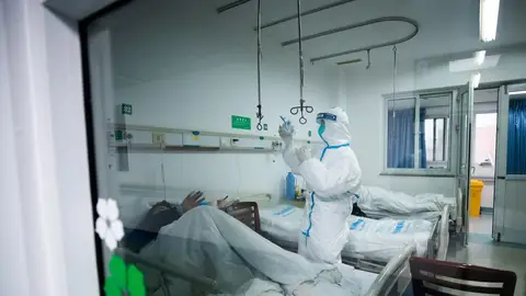 Un sanitario atendiendo a un paciente de coronavirus Un sanitario atendiendo a un paciente en un hospital de Wuhan, China