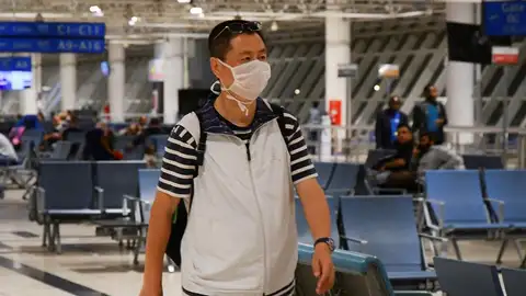 Viajeros con mascarillas en el aeropuerto Viajeros con mascarillas en el aeropuerto