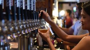 Una camarera sirviendo cerveza en un bar