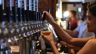 Una camarera sirviendo cerveza en un bar Una camarera sirviendo cerveza en un bar