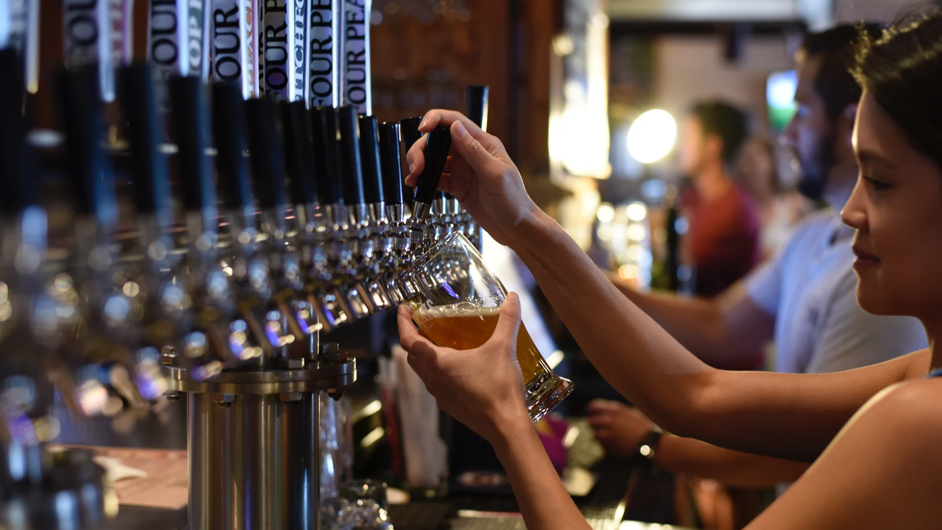 Una camarera sirviendo cerveza en un bar Una camarera sirviendo cerveza en un bar