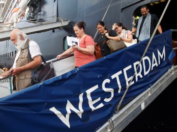 Algunos pasajeros descienden por la pasarela del crucero MS Westerdam