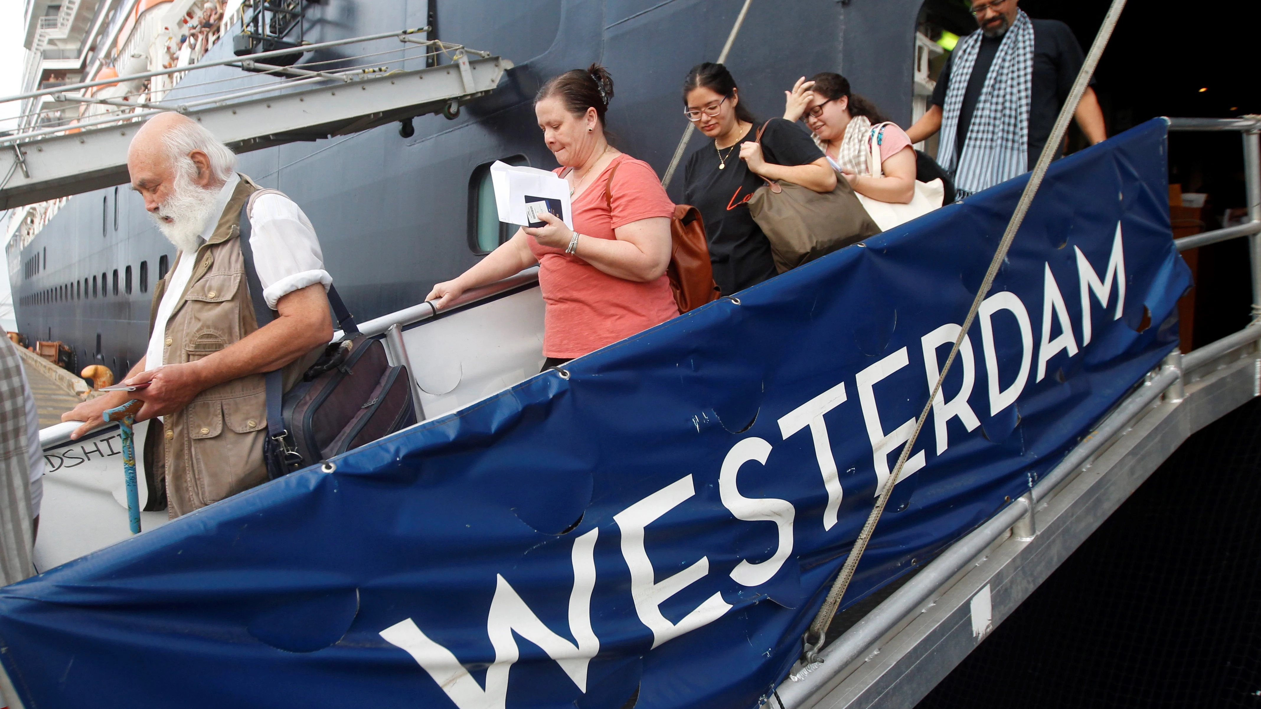Algunos pasajeros descienden por la pasarela del crucero MS Westerdam