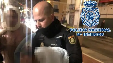 Uno de los policías sosteniendo al bebé en brazos Uno de los policías sosteniendo al bebé en brazos