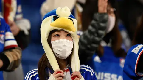 Una aficionada japonesa se protege de un posible contagio de coronavirus con una mascarilla Una aficionada japonesa se protege de un posible contagio de coronavirus con una mascarilla