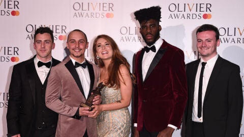 Elliot Warren, segundo por la izquierda, sosteniendo un premio Tony