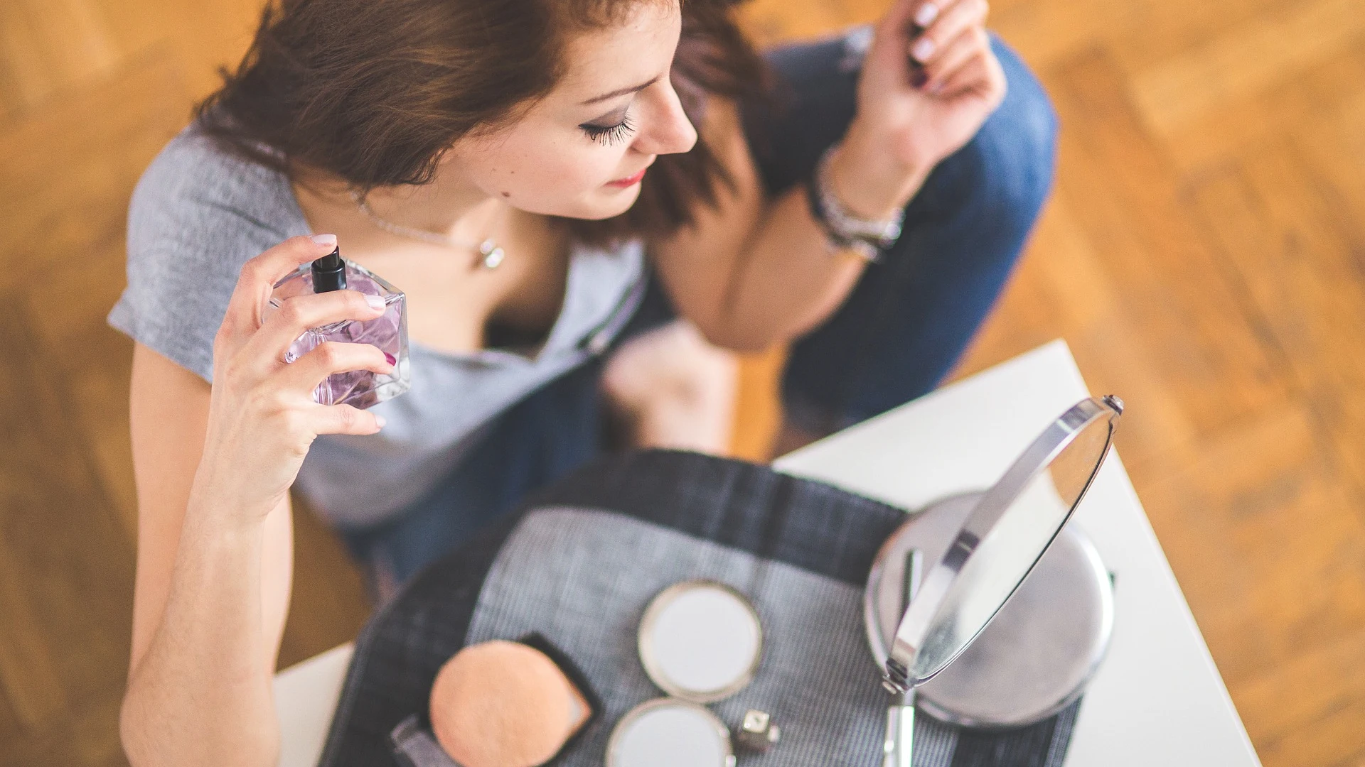 Mujer echándose perfume Mujer echándose perfume