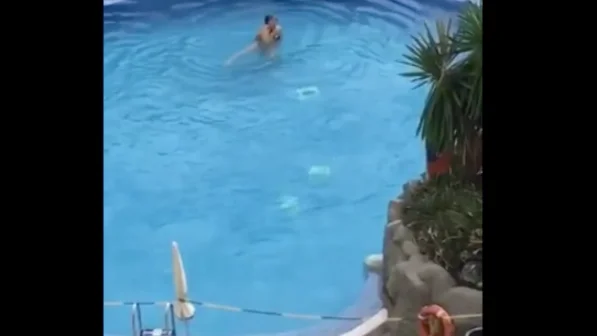 La mujer ba&ntilde;&aacute;ndose en la piscina