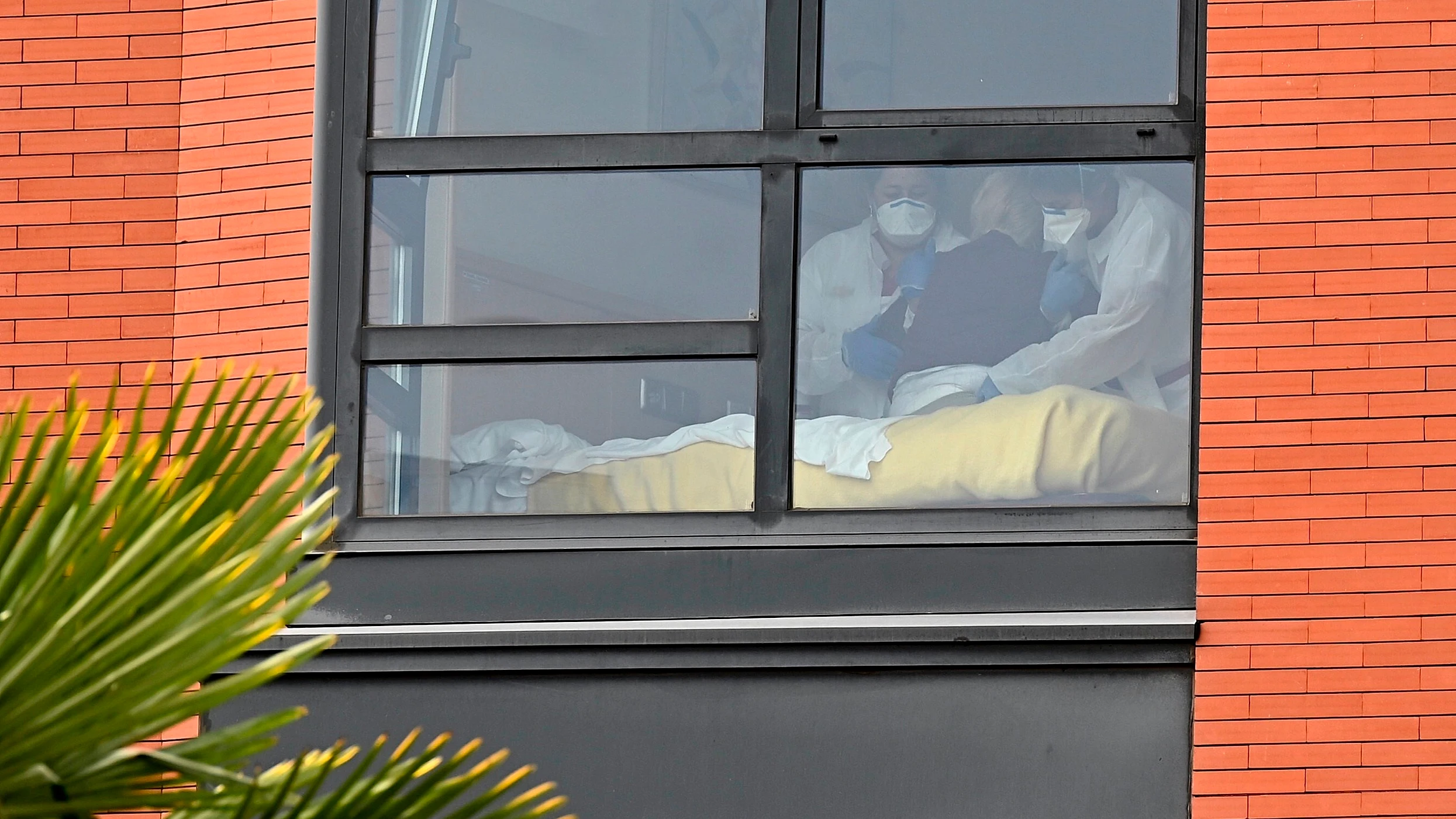 Dos trabajadoras asisten a un residente en la residencia de ancianos Monte Hermoso Dos trabajadoras asisten a un residente en la residencia de ancianos Monte Hermoso