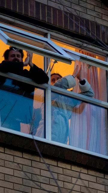 Dos personas asonadas a una ventana
