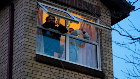 Dos personas asonadas a una ventana Dos personas asonadas a una ventana
