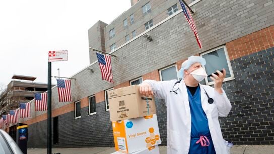 Un sanitario habla por tel&eacute;fono en Nueva York con la mascarilla puesta