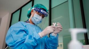 Una doctora con material de protecci&oacute;n manipulando un medicamento