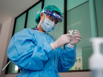 Una doctora con material de protección manipulando un medicamento Una doctora con material de protección manipulando un medicamento