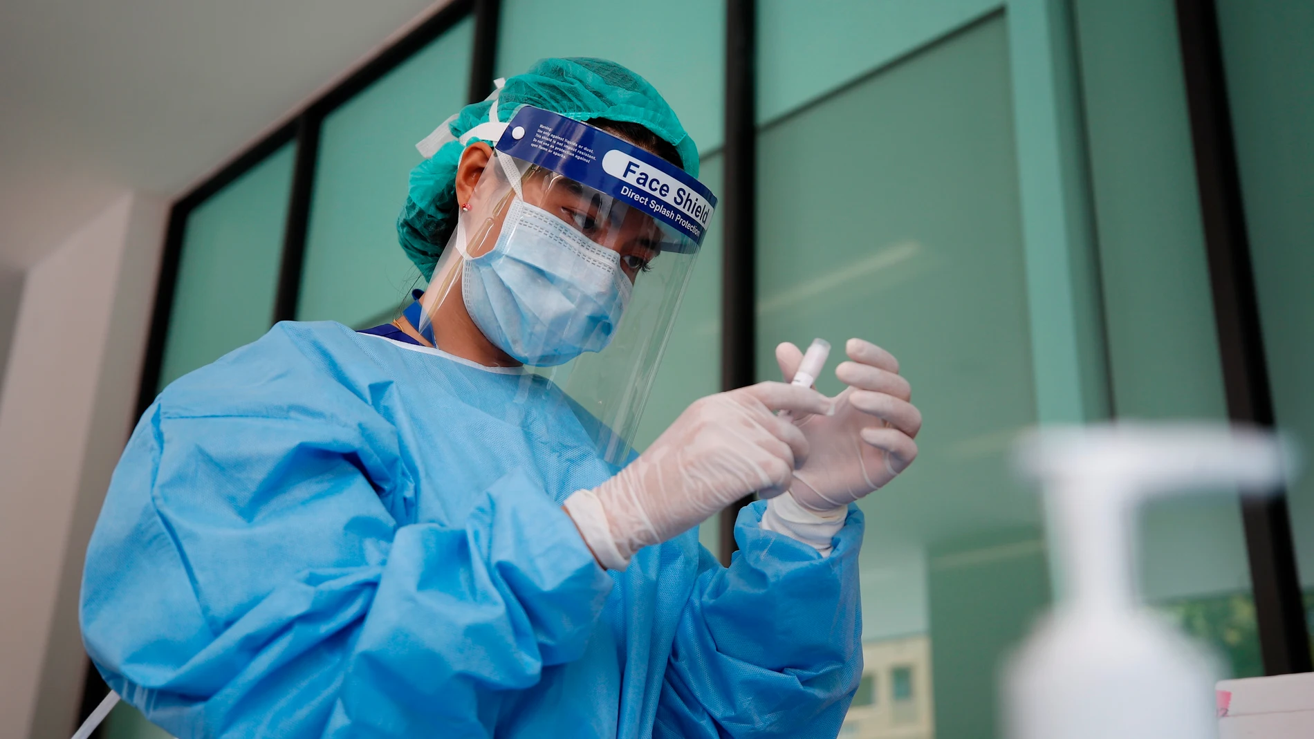 Una doctora con material de protección manipulando un medicamento Una doctora con material de protección manipulando un medicamento
