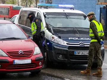 Un militar del Ejército y un agente de la Policía Nacional realizan controles de tráfico a la salida de la ciudad durante un viernes del estado de alarma Un militar del Ejército y un agente de la Policía Nacional realizan controles de tráfico a la salida de la ciudad durante un viernes del estado de alarma