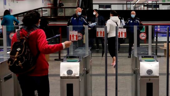 Polic&iacute;as entregan mascarillas en la estaci&oacute;n de metro de Nuevos Ministerios en Madrid