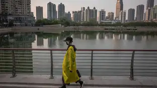 Una mujer camina junto a un lago de Wuhan (China) Una mujer camina junto a un lago de Wuhan (China)