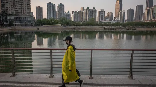 Una mujer camina junto a un lago de Wuhan (China) Una mujer camina junto a un lago de Wuhan (China)