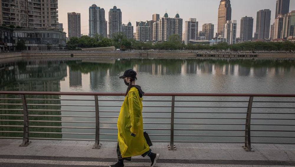 Una mujer camina junto a un lago de Wuhan (China)