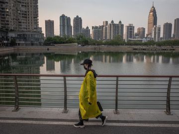 Una mujer camina junto a un lago de Wuhan (China)