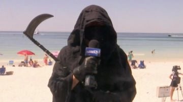Un hombre se viste de parca para protestar por la reapertura de las playas en Florida