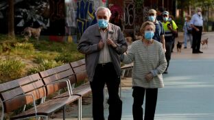 Una pareja protegida con mascarillas pasea por la Rambla Nova de Sants