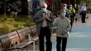 Una pareja protegida con mascarillas pasea por la Rambla Nova de Sants Una pareja protegida con mascarillas pasea por la Rambla Nova de Sants