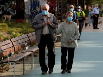 Una pareja protegida con mascarillas pasea por la Rambla Nova de Sants