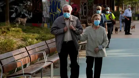 Una pareja protegida con mascarillas pasea por la Rambla Nova de Sants Una pareja protegida con mascarillas pasea por la Rambla Nova de Sants