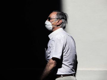 Una persona protegida con mascarilla recorre una calle en Valencia.