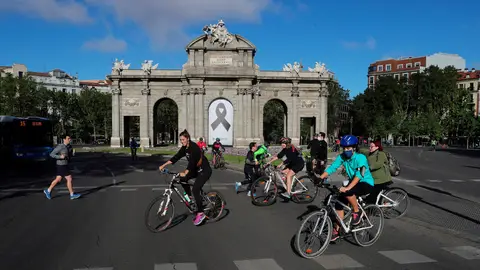 Vista de la Puerta de Alcalá con un crespón negro junto a la gente haciendo deporte en Madrid madrid