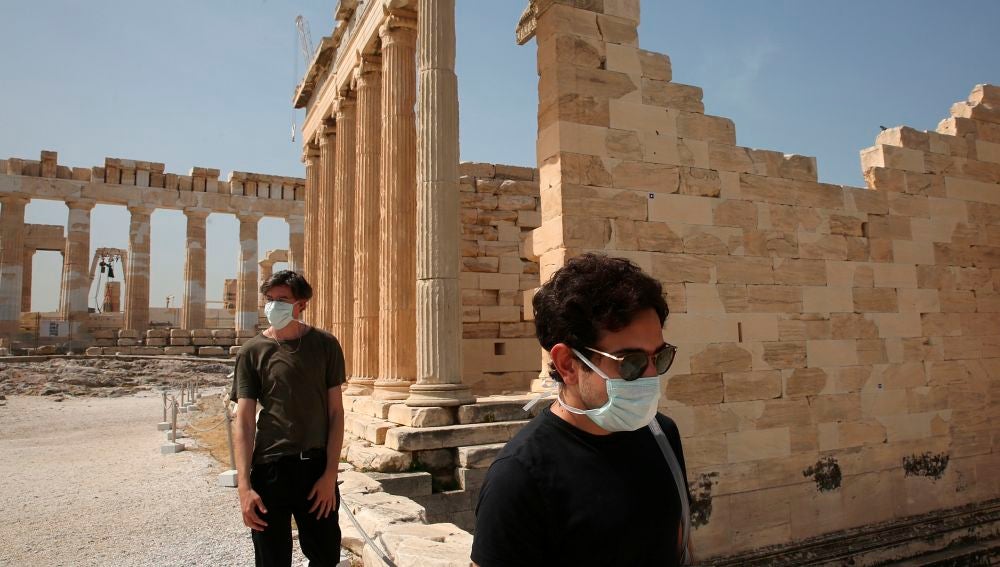 Dos turistas con mascarilla en la Acrópolis de Atenas