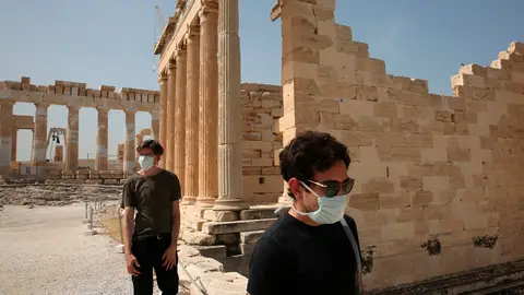 Dos turistas con mascarilla en la Acrópolis de Atenas Dos turistas con mascarilla en la Acrópolis de Atenas