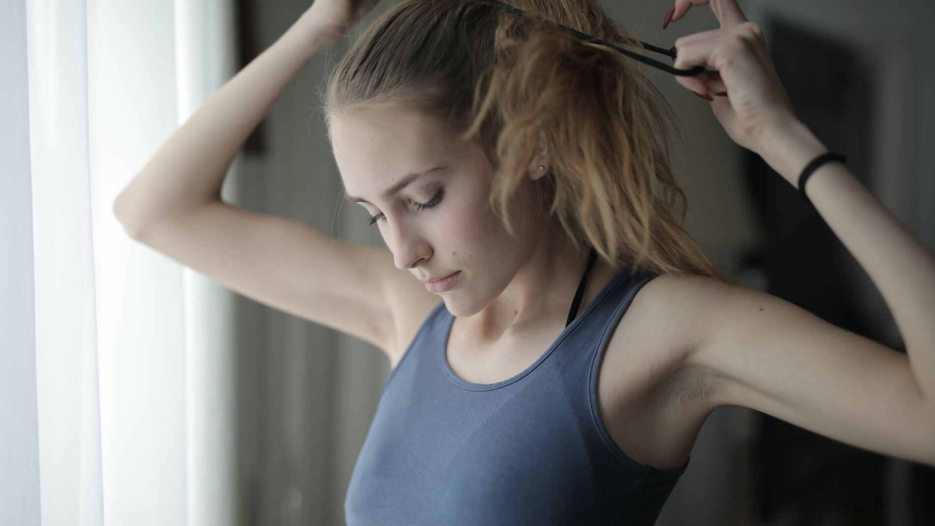 Chica haciéndose una coleta