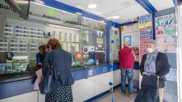 Varias personas acuden a una administración de lotería de Zaragoza este lunes