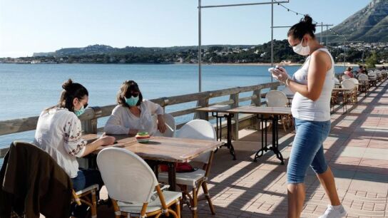 Clientes con mascarillas en una terraza