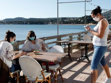 Clientes con mascarillas en una terraza