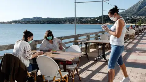 Clientes con mascarillas en una terraza Clientes con mascarillas en una terraza