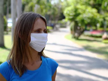Una mujer en la calle con mascarilla Una mujer en la calle con mascarilla