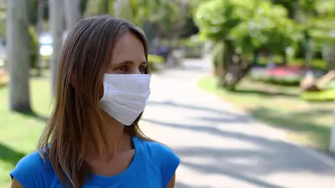 Una mujer en la calle con mascarilla