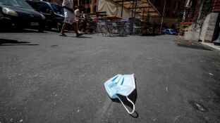 Imagen de una mascarilla de protecci&oacute;n tirada en el suelo en una calle de Roma
