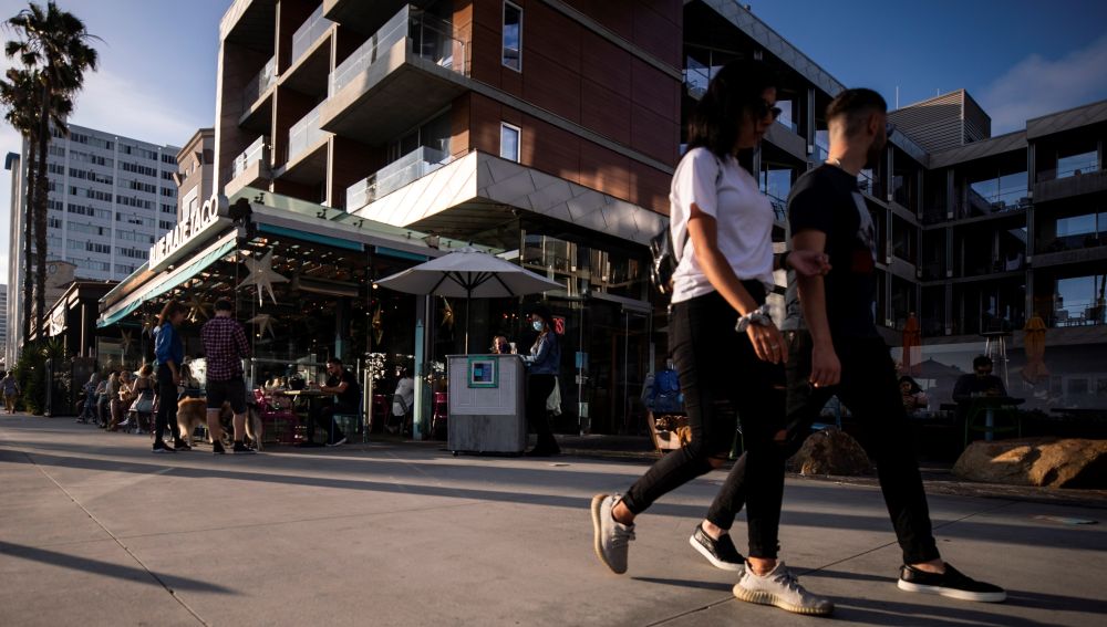 Turistas pasean por Santa Mónica, Estados Unidos, sin usar mascarilla