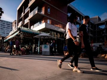 Turistas pasean por Santa Mónica, Estados Unidos, sin usar mascarilla