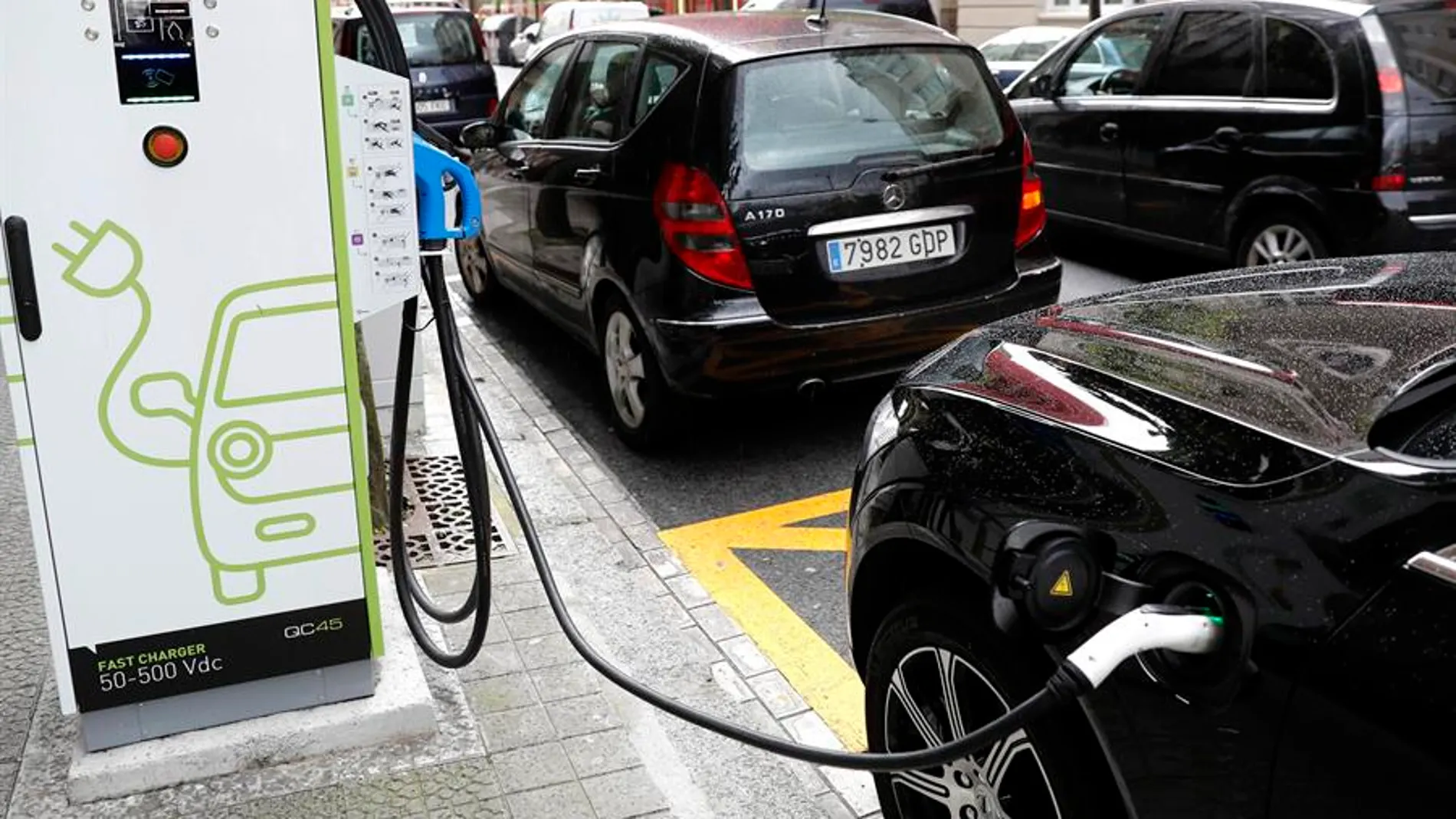 Coche enchufado a una estación de carga Coche enchufado a una estación de carga