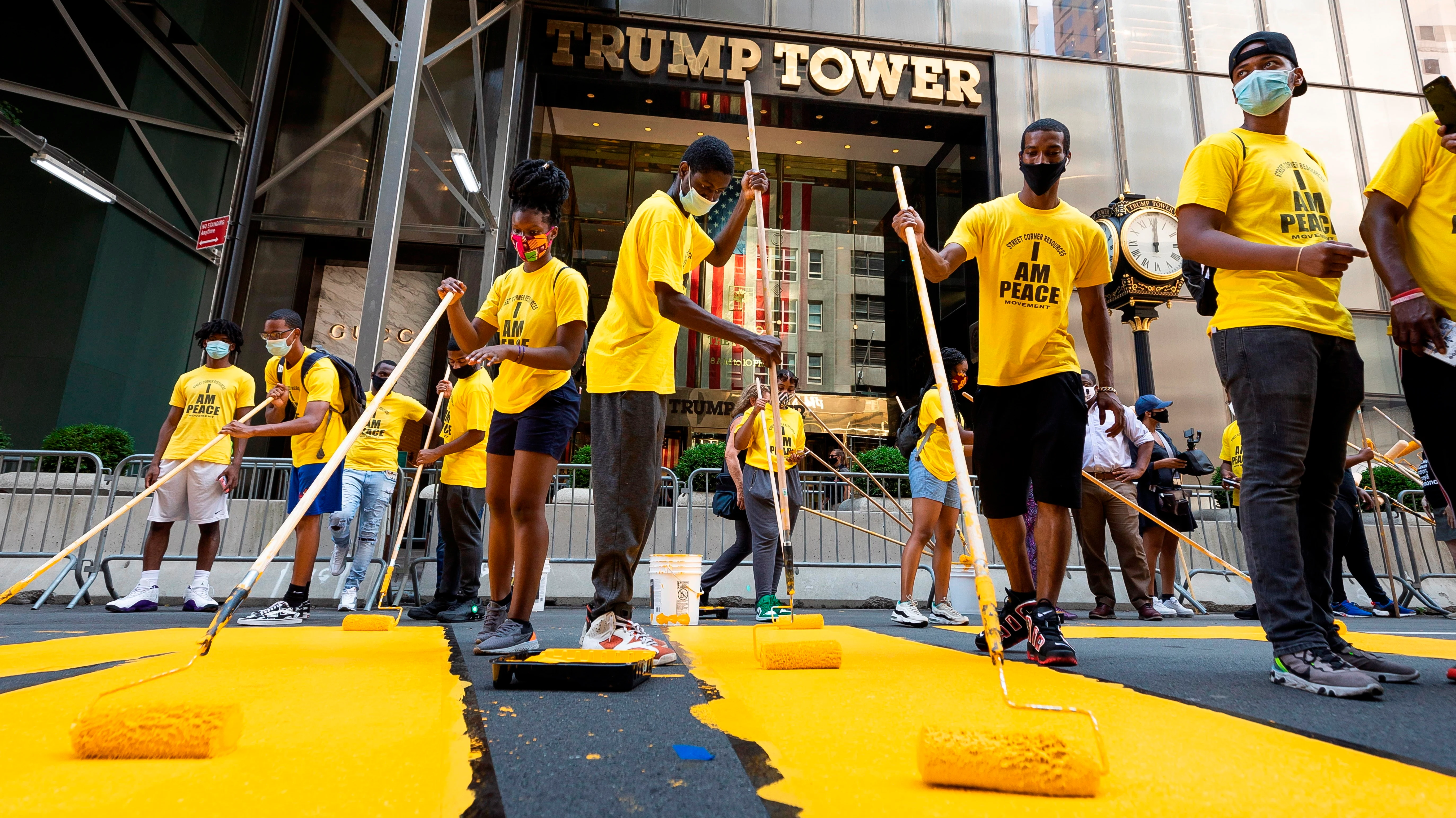 Voluntarios ponen los toques finales al enorme eslogan amarillo de "Black Lives Matter" en la calzada frente a la Torre Trump de Nueva York Voluntarios ponen los toques finales al enorme eslogan amarillo de "Black Lives Matter" en la calzada frente a la Torre Trump de Nueva York