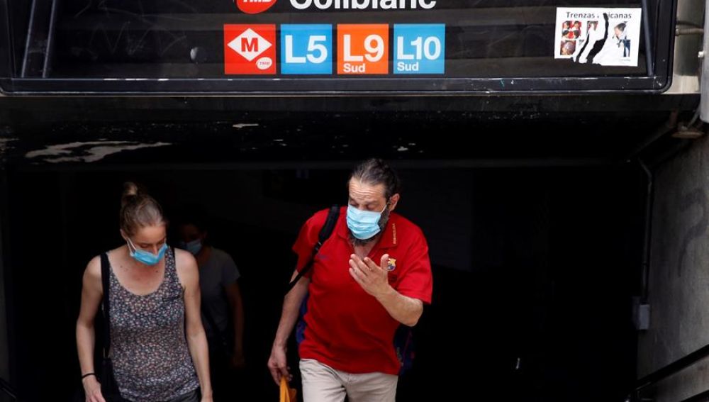 Viajeros salen con mascarilla del metro de Barcelona