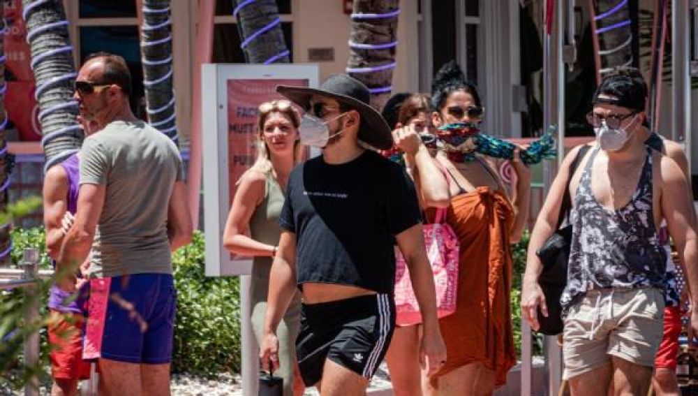 Un grupo de personas pasea con mascarilla por Miami